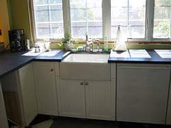 Mix and match soapstone countertops with other materials like this white apron sink to add contrast and interest to your kitchen design.