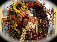 Sunflowers, maize and a plaid bow create a classic fall wreath design.