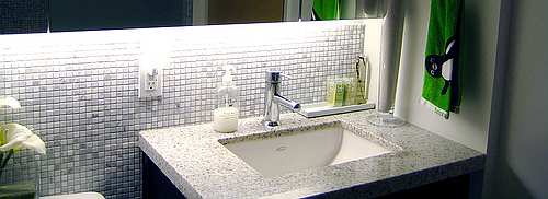 An under-mounted sink, granite countertops and tumbled marble backsplash produce a fabulous designer showcase bathroom.