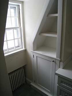 Tucked away in a corner under the roof rafters, this bathroom features a nice set of storage shelves.