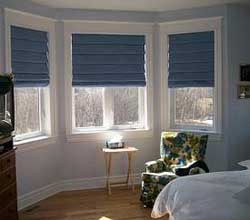 Awkward-shaped windows such as bay windows require extra thought. Here a set of roman shades allows flexible light control for a large bay window.
