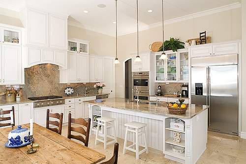 White cabinetry allows the color in decorative elements and the natural textures of stone and wood to make a greater impact in your country decor.