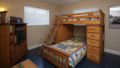You can find many dinosaur-patterned bedding sets that are inexpensive as well as accessories such as the dinosaur lamp in this lucky boys bedroom!