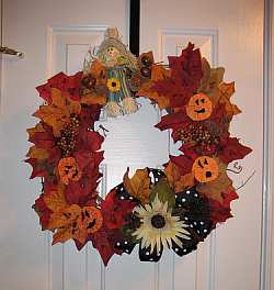 Scarecrows, fall leaves and Jack O Lanterns create a cute Halloween door wreath.