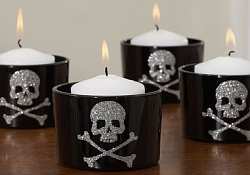 Create your own Halloween votives decorating aluminum cans or small plastic containers like these skull and cross bones designs.