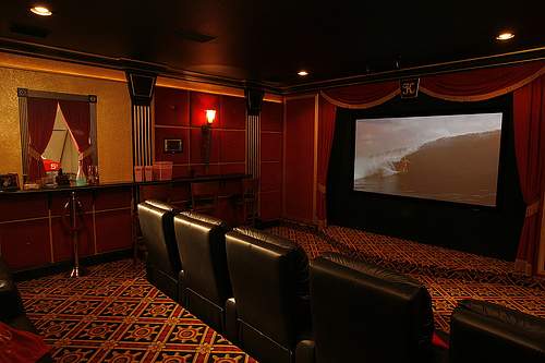 A classis movie theater theme is the most popular design motif. Here we see a very upscale home theater decor with deep, rich colors, plenty of wall sconces and accent lighting and a diamond pattern design refrain.