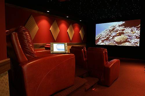Dedicated leather home theater seats with sleek, modern lines and integrated features such as programmable touch screen remote storage compartments and deep, wide recliners for optimal viewing comfort.
