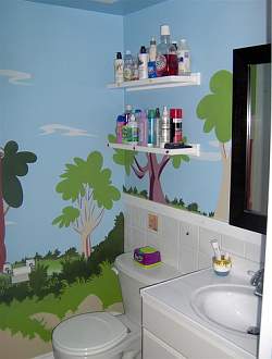 A hand painted wall mural adds fun and interest to the kids bathroom design!