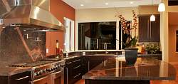 Dark granite countertops create visual interest and contrast in this modern style kitchen design.