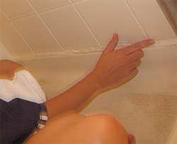 Wet your fingertip to smooth the beads of fresh caulk.